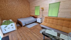ニーツァにあるSP camping Spāres Prieduļiのベッドルーム1室(ベッド1台、ソファ付)