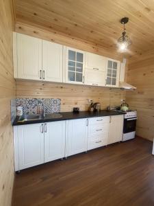 a kitchen with white cabinets and a stove at Skupis kokhebi in Mestia