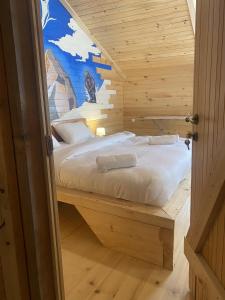 Łóżko w drewnianym pokoju z malowidłem ściennym w obiekcie Skupis kokhebi w mieście Mestia