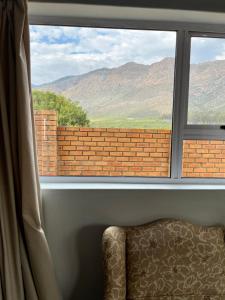 a window with a chair and a view of mountains at Dux in Montagu