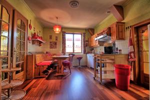 a kitchen with wooden floors and a table in it at Appartements & Chambres Les Loges du Capucin in Kaysersberg