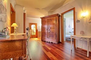 a kitchen with a wooden cabinet and a mirror at Appartements & Chambres Les Loges du Capucin in Kaysersberg