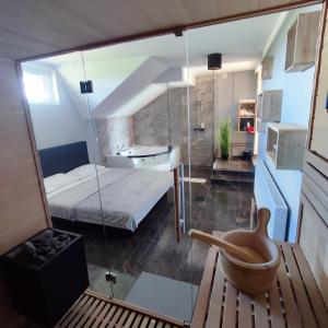 uma casa de banho com um quarto de vidro com uma cama e um lavatório em Guesthouse and Wellness VINEA em Spodnji Ivanjci