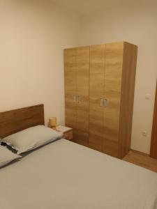 Schlafzimmer mit einem Bett und einem Holzschrank in der Unterkunft Kuća za odmor Grupković in Ploče