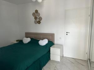 um quarto com uma cama verde e 2 almofadas brancas em Confortabil si modern em Bucareste