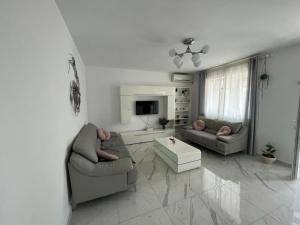 uma sala de estar com dois sofás e uma televisão em Confortabil si modern em Bucareste