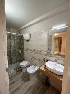 y baño con lavabo, aseo y espejo. en Casa Vacanze Arcobaleno, en Gasponi