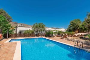 a swimming pool with blue water in a yard at Boutique Hotel Oriola in Cala de Sant Vicent