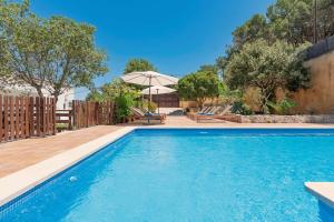 a swimming pool in a backyard with an umbrella at Boutique Hotel Oriola in Cala de Sant Vicenc