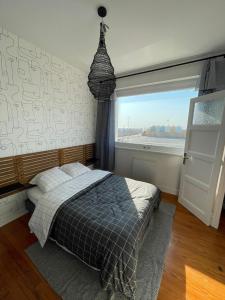 1 dormitorio con cama y ventana grande en l'albatros "le pont" en Cayeux-sur-Mer