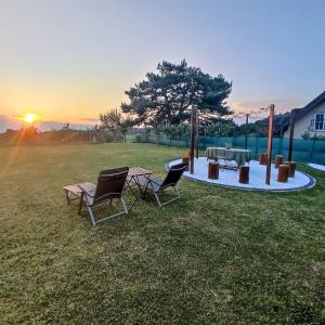 un grupo de sillas y una mesa de picnic en un campo en Guesthouse and Wellness VINEA en Spodnji Ivanjci