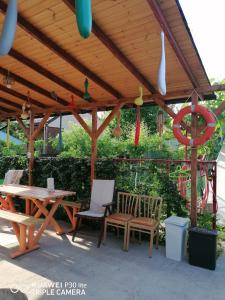 a wooden pergola with a table and chairs under it at Casa OZZY&PATTY in 2 Mai