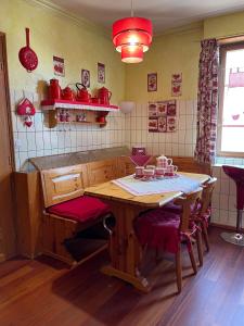 una cucina con tavolo in legno e sedie rosse di Appartements & Chambres Les Loges du Capucin a Kaysersberg