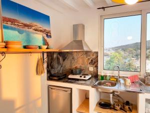 a kitchen with a stove and a sink and a window at Archipelagos Kimolos sea view in Kimolos