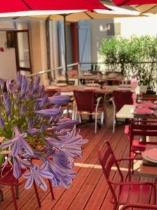 a bouquet of purple flowers sitting on a deck at Hôtel restaurant l'escale chez mimi in Bioule