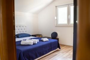 um quarto com uma cama azul com toalhas em Holiday Home Vemini em Mostar