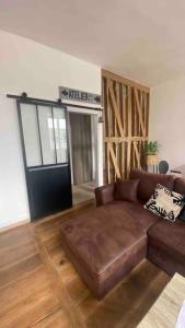a living room with a brown leather couch in a room at Appartement Dol de Bretagne centre in Dol-de-Bretagne