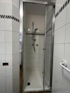 una doccia con porta in vetro in bagno di B&B La Farfalla a Pescara
