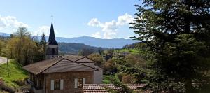 a church with a steeple on a hill with a village at L 'EDELWEISS de 1 a 9 personnes in Nerpol-et-Serres