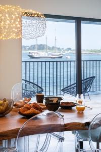 - une table avec de la nourriture et une vue sur l'eau dans l'établissement ILE CEZON - Duplex de luxe avec magnifique vue mer, à Landéda
