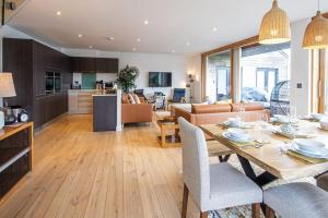 a kitchen and living room with a table and chairs at Waters Edge 15, Kingsholm P in South Cerney