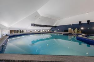 a large swimming pool with blue water at Waterside Apartment in Paignton