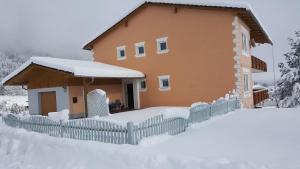 uma casa com uma cerca coberta de neve em Appartment Gailtalblick em Nötsch