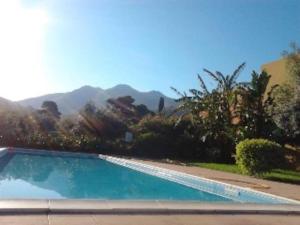 een zwembad in een tuin met bergen op de achtergrond bij Villetta Casa Rosa in Castelluzzo