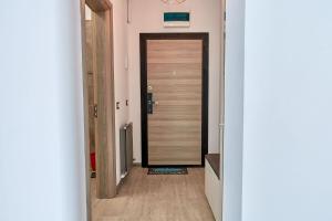 a hallway with a wooden door in a room at Apartament Melody by Alz in Mamaia Nord +49 photos