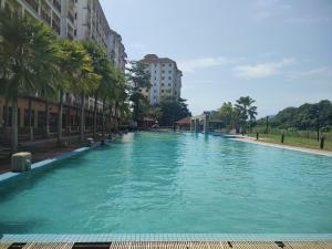 a large swimming pool with palm trees and buildings at Sofea Inn Bukit Merah - Suria A7727 in Kampong Selemat