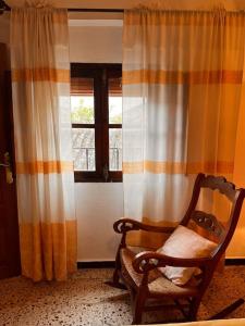 BenarrabáにあるCasa Veracruzの椅子と窓が備わる客室です。