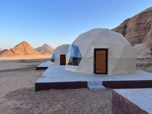 three tents in the desert with mountains in the background at Wild Oryx Camp Bubbles in Disah