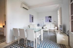 a dining room with a glass table and white chairs at 42par1049 - Super Bright 3BR in Sant Antoni in Barcelona