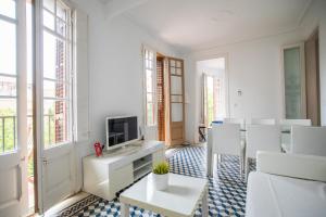 a living room with white furniture and a tv at 42par1049 - Super Bright 3BR in Sant Antoni in Barcelona
