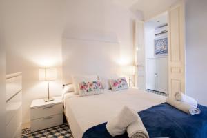 a white bedroom with a large bed with two pillows at 42par1049 - Super Bright 3BR in Sant Antoni in Barcelona