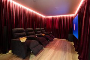 a theater room with red curtains and a set of chairs at Boutique ChaletS Alpi - Private Sauna & Cinema in Garmisch-Partenkirchen