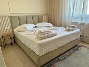 1 dormitorio con 1 cama grande y toallas. en Sea View Apartments ELDO, en Durrës