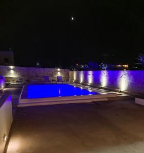 una piscina por la noche con luces azules en Ftelia Breeze en Klouvas
