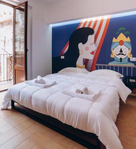 a bedroom with a large bed with a painting on the wall at Kalos Apartments Catania in Catania