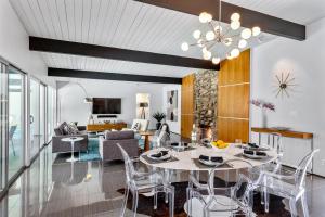 a dining room and living room with a table and chairs at Aqua House in Palm Springs