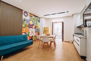 a living room with a blue couch and a table at Kalos Apartments Catania in Catania