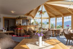 a restaurant with tables and chairs and windows at Hotel-Appartement Hochkönig in Ramsau am Dachstein