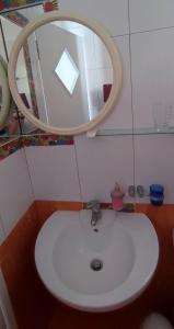 W łazience znajduje się biała umywalka i lustro. w obiekcie Filina's Studio w mieście Maltezana