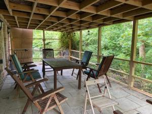 a screened in porch with chairs and a table at Lodge 1, The Grange in Wick