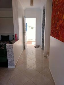 a room with a hallway with a door and a tile floor at Villa Mama Swiriya Atlantique in Souira Guedima