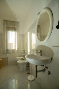 a white bathroom with two sinks and a mirror at Bed and Breakfast La Marianaccia in Marsiliana