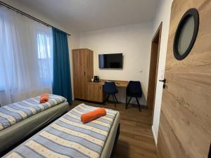 Habitación de hotel con 2 camas y escritorio en Cztery Pory Roku en Ustronie Morskie