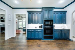 een blauwe keuken met witte muren en houten vloeren bij Luxury Texas Villa on 10 Acres with Pool and Pond! in McKinney