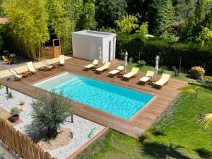 a swimming pool in a backyard with lounge chairs and a swimming poolvisor at Hôtel Le Grain de Sable in Arès