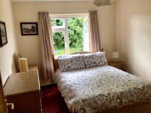 a bedroom with a bed in front of a window at Swilly View House in Ramelton
